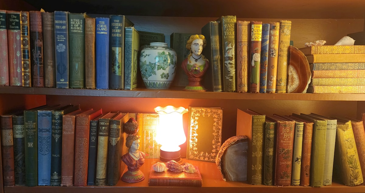 Biblioteca pessoal com livros antigos e luz quente, evocando estudo e tradição filosófica.
